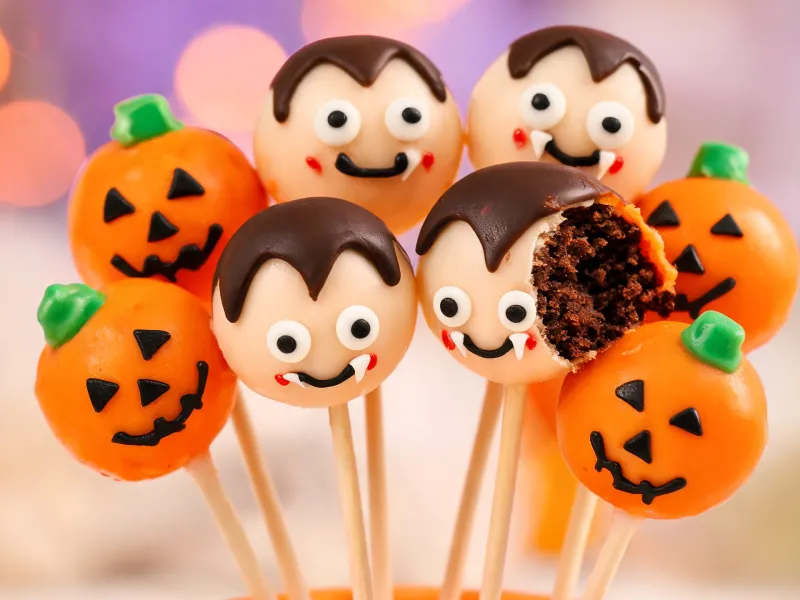 Schoko-Cake-Pops als Kürbisse und Vampire (KI-generiertes Bild)