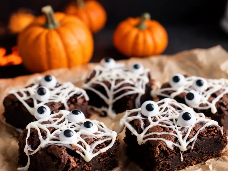 Brownies mit Spinnennetzen aus Marshmallow und Zuckeraugen (KI-generiertes Bild)