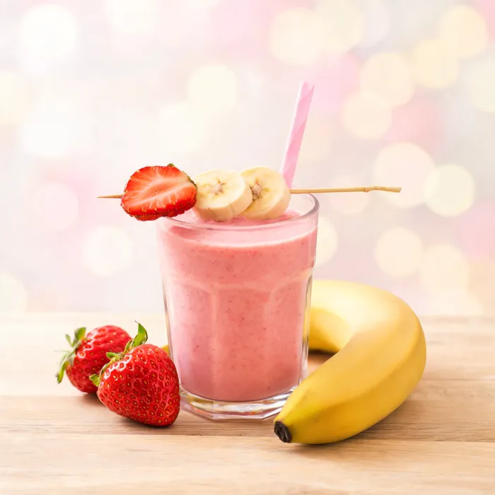 Rosa Erdbeer-Bananen-Smoothie mit Fruchtspieß (KI-generiertes Bild)