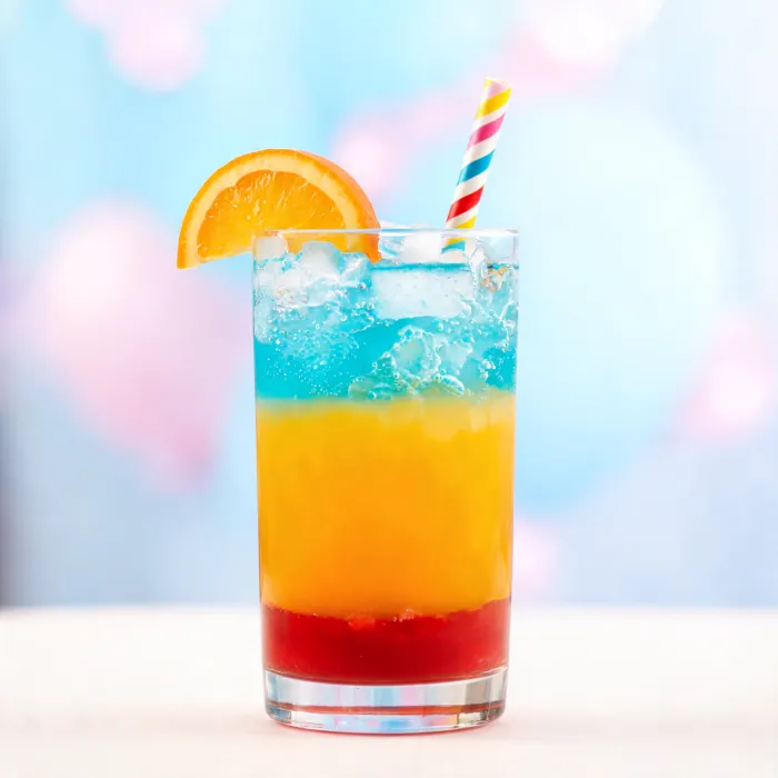 Geschichteter Saft in Rot, Orange und Türkis mit Orangenscheibe (KI-generiertes Bild)