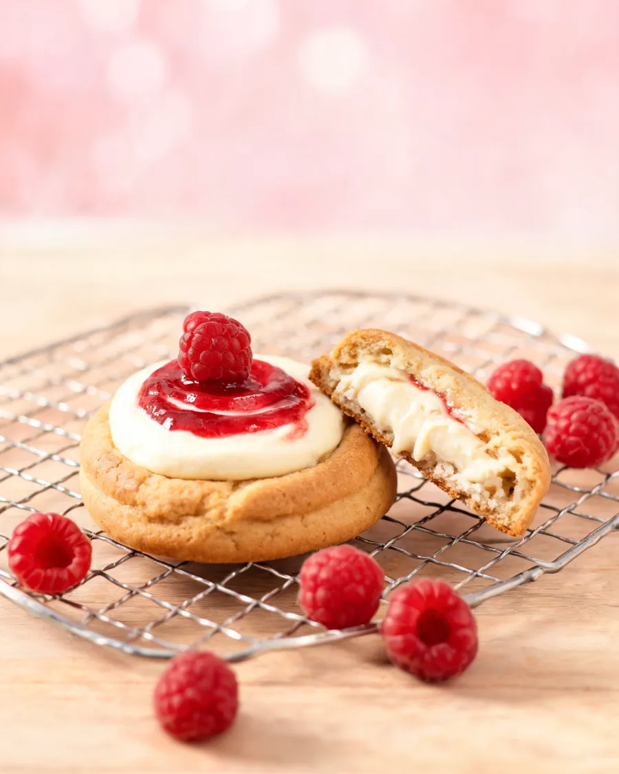 Weiche Cookies mit Frischkäse-Füllung, Himbeermarmelade und einer Himbeere in der Mitte (KI-generiertes Bild)
