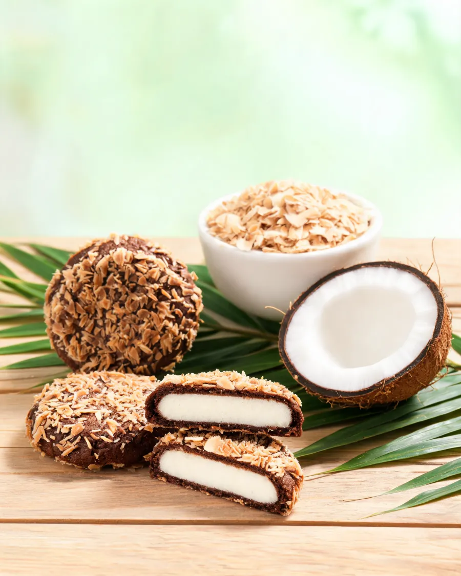 Runde Schoko-Kekse mit Kokosraspel-Hülle, einige halbiert mit weißem Kokos-Keksteig innen (KI-generiertes Bild)