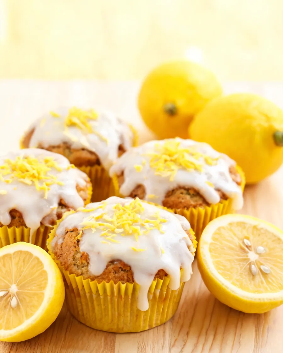 Zitronen-Muffins mit weißem Zitronenguss und Zitronenschale (KI-generiertes Bild)